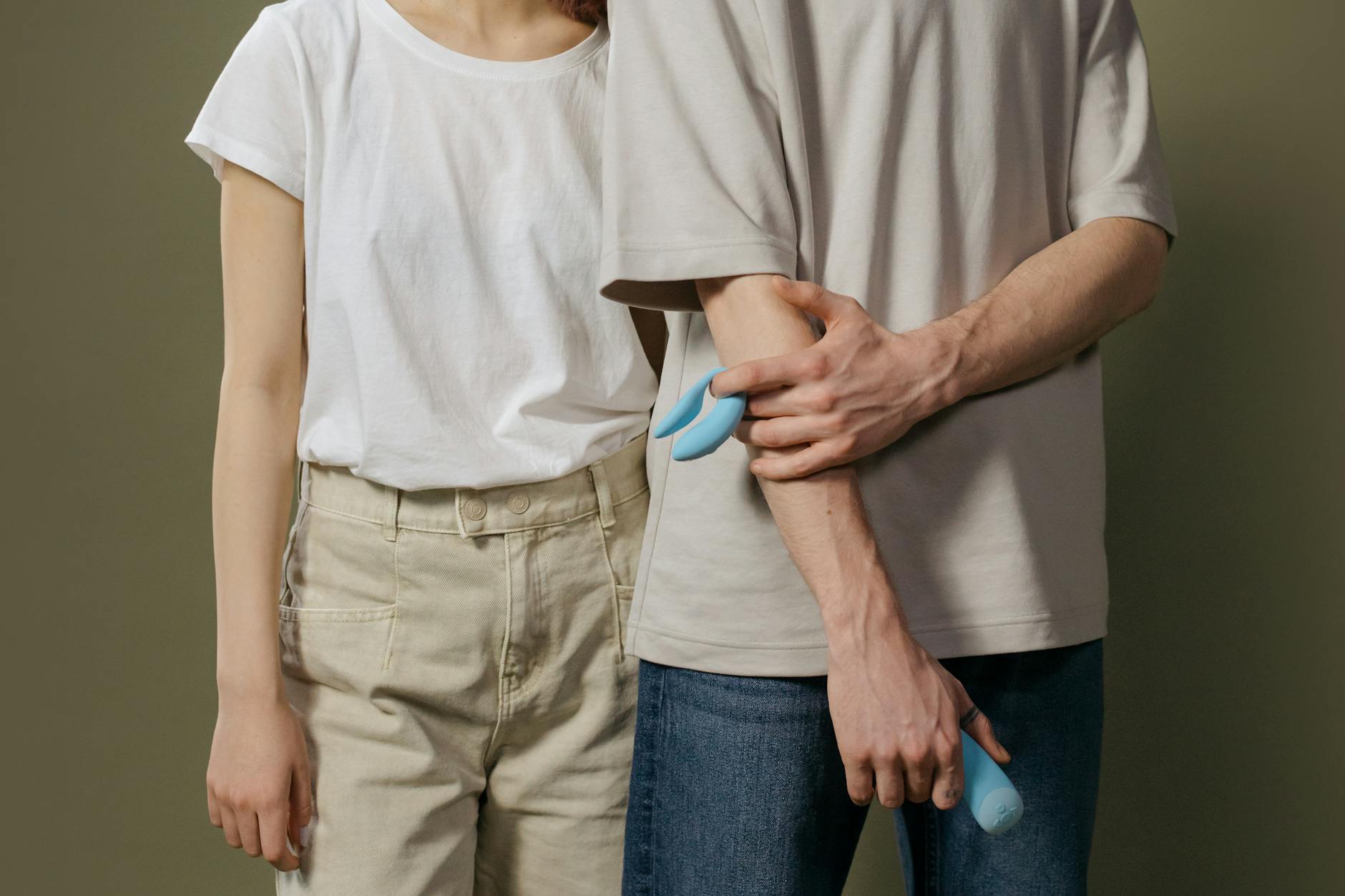 A couple exploring intimacy together with a blue vibrator, representing reconnection during hormonal transitions.